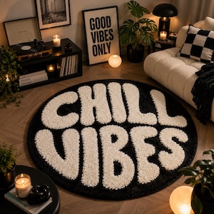 Puede incluir: Una alfombra circular con fondo negro y el texto CHILL VIBES escrito en letras grandes, blancas, texturizadas y con mechones. La alfombra tiene un aspecto suave y afelpado y está colocada sobre un suelo de madera en una sala de estar.