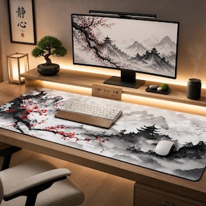 Peut inclure: Tapis de bureau rectangulaire avec un motif inspiré du Japon. Le tapis présente un paysage en noir et blanc avec des touches florales rouges. Un clavier et une souris sont posés sur le tapis, avec un écran d'ordinateur en arrière-plan.