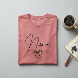 Op de afbeelding: Een witte keramische mok met een zwarte handgreep en de tekst "But First, Coffee" in een vetgedrukte, zwarte letter. De mok staat tegen een vage achtergrond, wat een gezellige setting suggereert.