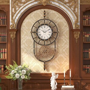 May include: A vintage-style wall clock with a black frame and gold detailing. The clock face is white with black Roman numerals. Below the clock face are decorative gold gears. The clock is mounted on patterned wallpaper.