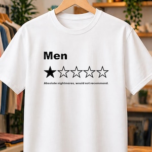 May include: A white short-sleeved t-shirt featuring the black text Men above a graphic of five stars, with only the first star filled in black. Below the stars, the black text reads Absolute nightmares, would not recommend.