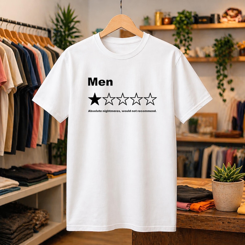 May include: A white short-sleeved t-shirt featuring the black text Men above a graphic of five stars, with only the first star filled in black. Below the stars, the black text reads Absolute nightmares, would not recommend.