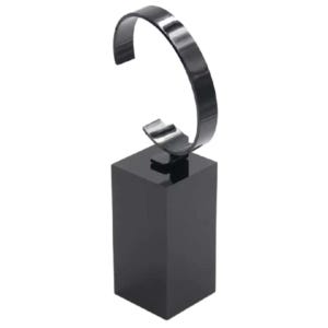 May include: A glossy black watch display stand featuring a rectangular base and a curved, C-shaped holder designed to support a wristwatch. The entire structure has a smooth, reflective finish and is constructed from a solid, dark material.