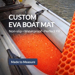 K&ouml;nnte beinhalten: Eine leuchtend orangefarbene EVA-Bootmatte mit erhabener, sechseckiger Wabenstruktur, die in einem hellgrauen Schlauchboot liegt. Die Matte hat eine rutschfeste Oberfl&auml;che und ist mit dem Textaufdruck CUSTOM EVA BOAT MAT versehen.