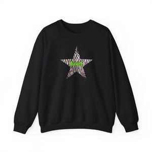 May include: Black crewneck sweatshirt featuring a zebra-striped star graphic. The star contains the word "brat" in neon green. The sweatshirt has long sleeves and a classic, casual design.