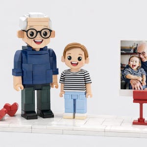 May include: A custom building block set featuring two figures: an older adult with white hair and glasses in a blue sweater, and a child in a striped shirt and light blue pants. Two red heart blocks and a photo stand with a picture are included.