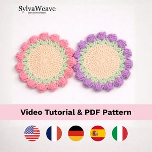 Op de afbeelding: Twee handgemaakte gehaakte onderzetters. Eén is roze en de andere is paars. Beide hebben een lichtperzikkleurig midden, een groene rand en een geschulpte rand. De tekst "SylvaWeave CROCHET PATTERN" staat bovenaan. De tekst "Video Tutorial & PDF Pattern" staat onderaan.