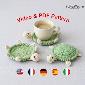 Può includere: Tre sottobicchieri all'uncinetto a forma di tartaruga in verde chiaro e crema con occhi a perla neri. Un sottobicchiere sostiene una tazza in ceramica bianca piena di caffè. Il testo recita SylvaWeave Crochet Pattern e Video & PDF Pattern, accompagnato da cinque icone circolari di bandiere nazionali.