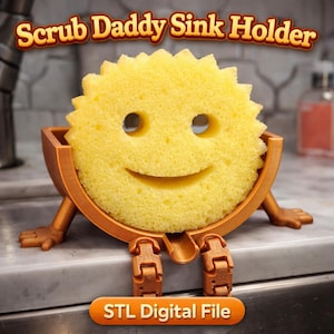May include: A yellow Scrub Daddy sponge with a smiling face, held in a brown sink holder with legs. The text "Scrub Daddy Sink Holder" is at the top, and "STL Digital File" is at the bottom.