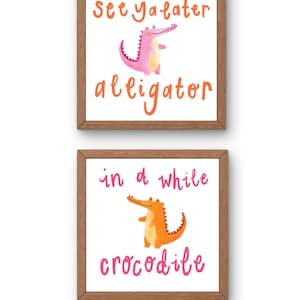 Könnte beinhalten: Zwei gerahmte Kunstdrucke mit weißem Hintergrund. Der obere Druck zeigt einen rosa Alligator mit dem Text "See ya later alligator" in Orange. Der untere Druck hat ein orangefarbenes Krokodil und den Text "in a while crocodile" in Pink.