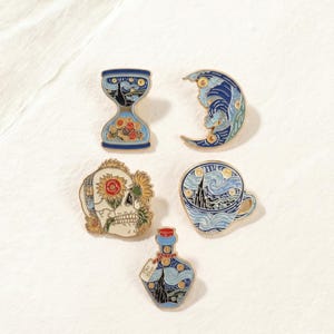 May include: A collection of enamel pins featuring designs inspired by Van Gogh's "Starry Night." Includes an hourglass, crescent moon, skull with sunflowers, a teacup, and a bottle with a tag that says "The Star."