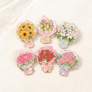 Op de afbeelding: Zes emaille pins met bloemboeketten. De boeketten bevatten zonnebloemen, tulpen, lelies, calla's, rozen en pioenrozen. Elk boeket is verpakt in papier en vastgebonden met een lint.