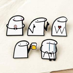 May include: A collection of five white enamel pins. Each pin features a cartoon character with a black outline, displaying different emotions. The character is shown holding a flower, giving a thumbs up, with a heart, holding a beer, and crying.
