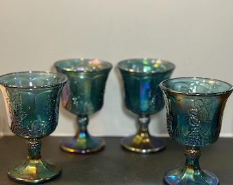 Set of four iridescent blue carnival glass goblets with grape motif.
