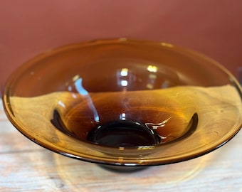 Uma tigela vintage de vidro artístico âmbar soprado à mão com uma cor degradê.