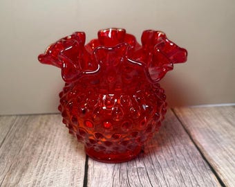 Dit is een rode Fenton Art Glass-vaas met een gegolfde rand.