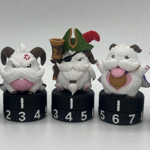 May include: Six white, furry, horned creature figurines, each mounted on a black circular base with white printed numbers ranging from 0 to 7. The characters feature various accessories including goggles, pirate hats, eye patches, and a grey hammer.