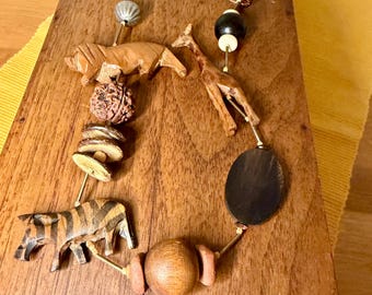 Collar llamativo de madera tallada a mano de los años 70-80 con diseño de animales de safari: jirafa, cebra y león.