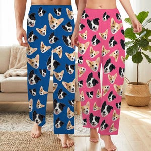 May include: Two pairs of lounge pants featuring an all-over print of dog faces. One pair is blue with a repeating pattern of Corgi and Border Collie heads, while the other pair is pink with the same repeating pattern of dog faces.