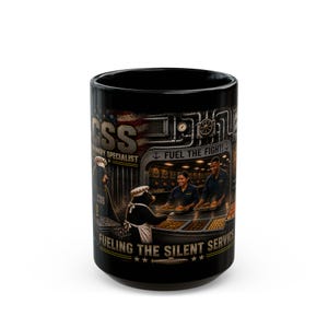 May include: A black ceramic mug featuring a graphic print of a bear in a chef hat and apron serving food alongside two people in a submarine galley. The text reads CSS CULINARY SPECIALIST FUEL THE FIGHT and FUELING THE SILENT SERVICE with a submarine.
