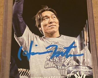 Puede incluir: Una tarjeta de béisbol Stadium Club que muestra a Hideki Matsui con una camiseta gris de la Serie Mundial de los New York Yankees con un brazo levantado. La tarjeta incluye un autógrafo en tinta azul, el texto HIDEKI MATSUI, DH/OF y el logo.