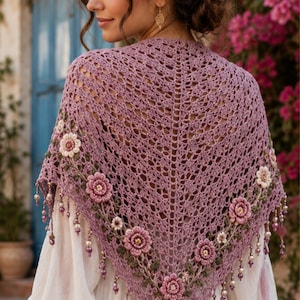 May include: A triangular mauve crochet shawl featuring an intricate openwork pattern, adorned with three-dimensional floral embroidery in shades of pink and cream, and finished with dangling beaded fringe along the bottom edges.