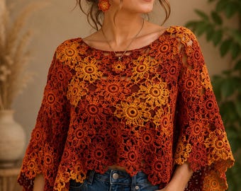 May include: A crochet poncho featuring a repeating floral motif in a gradient of warm colors, transitioning from deep rust red to bright yellow. The garment has a wide neckline, short sleeves, and a scalloped hemline, paired with blue denim jeans.