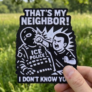 May include: Black and white embroidered patch with the text "THAT'S MY NEIGHBOR!" and "I DON'T KNOW YOU." The patch depicts a cartoon image of a person punching another person wearing an "ICE POLICE" uniform.