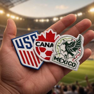 May include: Patches featuring the flags of the USA, Canada, and Mexico. The USA patch is blue and white with red stripes. The Canada patch is red with a white soccer ball. The Mexico patch is green, white, and red with an eagle emblem.