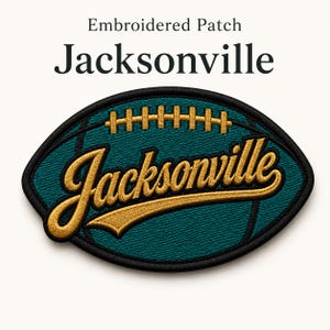 May include: Embroidered patch in the shape of a football, featuring the word "Jacksonville" in gold script. The patch has a teal background with gold stitching and a black border. The text "Embroidered Patch" is above the football.