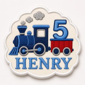 May include: An embroidered patch with a scalloped edge featuring a dark blue steam locomotive, a red train car carrying a large blue number 5, and grey smoke clouds. The name HENRY is stitched in blue capital letters at the bottom of the patch.
