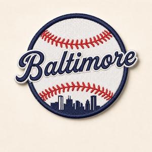 May include: Embroidered baseball patch featuring the word "Baltimore" in navy blue script. The patch has a white baseball design with red stitching and a navy blue border. A navy blue skyline is at the bottom.
