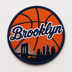 May include: Embroidered patch featuring a basketball design with the word "Brooklyn" in white script. The patch includes a silhouette of the Brooklyn Bridge and city skyline in navy blue against an orange background.