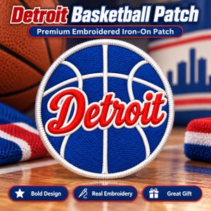 May include: A circular embroidered iron-on patch featuring a blue basketball design with white lines and the word Detroit in red script lettering. The patch has a thick white stitched border and is displayed against a blurred sports background.