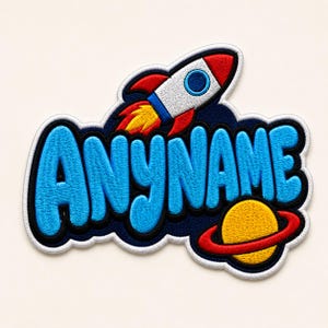May include: Embroidered patch featuring a rocket ship and a planet with a ring. The patch has the text "ANYNAME" in blue, outlined in black and white. The rocket is red, white, and blue, with yellow flames.