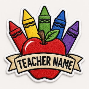 May include: An embroidered patch featuring a bright red apple with a green leaf, positioned behind a beige banner with the black text TEACHER NAME. Five colorful crayons in red, yellow, green, blue, and purple fan out behind the apple.