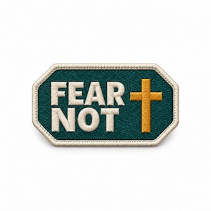 May include: A rectangular embroidered patch with clipped corners featuring a dark teal background, a beige border, and the white text FEAR NOT stacked in two lines next to a gold-colored Christian cross symbol on the right side.