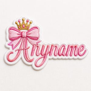 May include: Embroidered patch featuring the word "Anyname" in a cursive font, with a pink bow and a gold crown. The patch has a white border and is likely for clothing or accessories.
