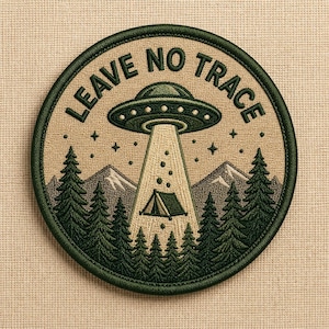 May include: Embroidered patch with a green border and the text "LEAVE NO TRACE". The design features a UFO beaming up a tent, with pine trees, mountains, and stars. The patch is circular and has a tan background.