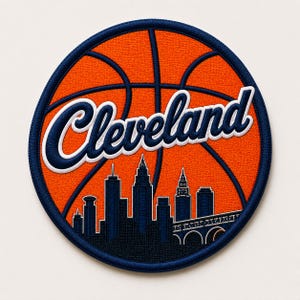 May include: A round patch featuring an orange basketball design with navy blue accents. The word "Cleveland" is written in white script with a navy blue outline. A navy blue skyline of Cleveland is at the bottom.