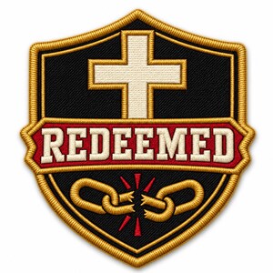May include: A shield-shaped embroidered patch with a black background and gold border. It features a white cross above a red horizontal banner with the word REDEEMED in white letters. Below the banner are two broken gold chain links with red accents.
