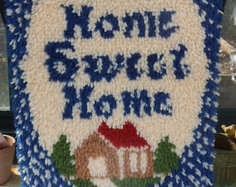 May include: A white and blue rug with the words "Home Sweet Home" in blue lettering. The rug also features a red heart with green leaves and a brown house with a red roof.