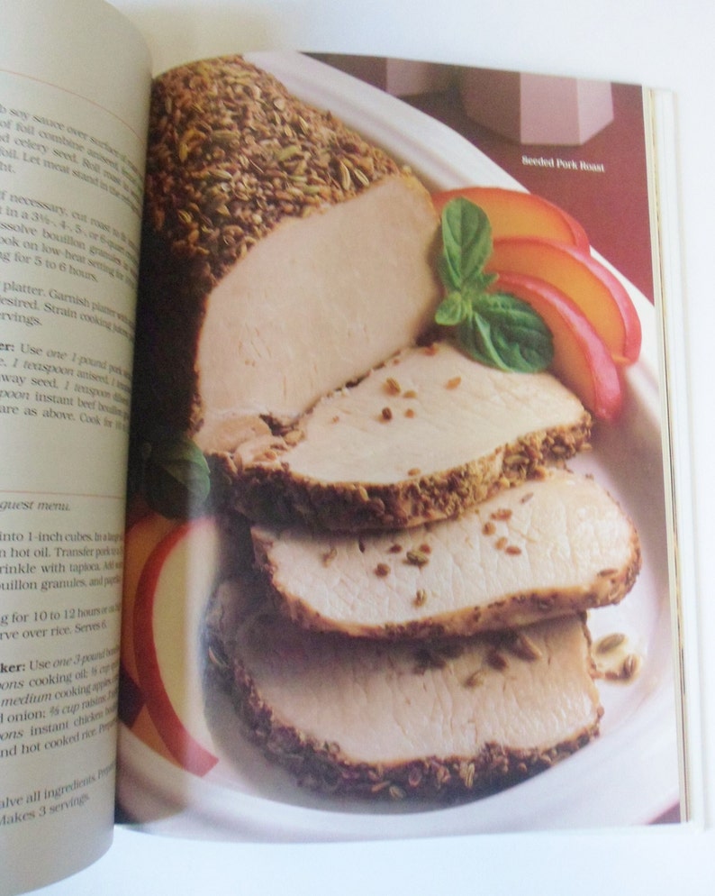 May include: A close-up of a sliced roasted pork loin with a crust of herbs and spices. The pork is on a white platter with slices of peach and basil leaves. The text "Breaded Pork Roast" is visible in the upper right corner of the image.