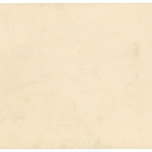 May include: A rectangular piece of aged paper in a light beige tone. The paper has a slightly textured surface with small imperfections and a few faint marks. A small red mark is visible in the upper left corner.