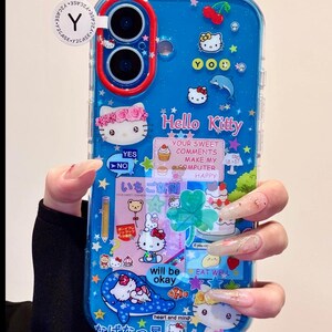May include: Blue phone case with a Hello Kitty theme. The case features various Hello Kitty designs, stars, and text. The text includes "Hello Kitty", "Your sweet comments make my computer happy", and "will be okay".