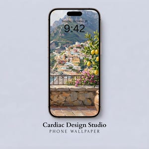 May include: A smartphone displays a scenic phone wallpaper. The wallpaper features a coastal Italian town with colorful buildings, mountains, and a lemon tree. The time is 9:42 on Sunday, October 17. The phone's screen is framed by a black border. Text at the bottom reads "Cardiac Design Studio PHONE WALLPAPER."