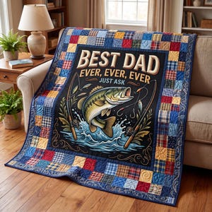 Puede incluir: Una colcha acolchada con temática de pesca. El centro presenta un gráfico de un pez saltando fuera del agua, con cañas de pescar a cada lado. El texto dice "BEST DAD EVER, EVER, EVER JUST ASK". El borde es un patchwork de varias telas a cuadros y lisas.