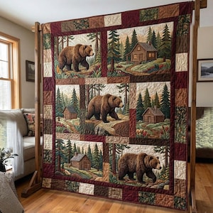 May include: A large quilt featuring four panels with brown bears and log cabins in a forest setting. The quilt has a patchwork design with a mix of earth-tone colours, including brown, green, and burgundy.