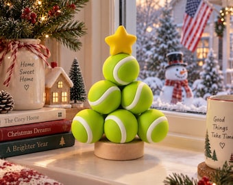 Puede incluir: Una escultura decorativa en forma de árbol construida con seis pelotas de tenis de color verde brillante apiladas en forma de pirámide, rematada con una estrella amarilla y montada sobre una base de madera circular.