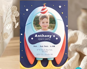 Puede incluir: Una invitación a una fiesta temática espacial con la foto de un niño dentro de un diseño de cohete. La invitación es azul marino con estrellas blancas y detalles en naranja y azul. El texto incluye "Anthony's space party".